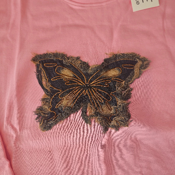 Pink garment with a decorative patch on a pink background