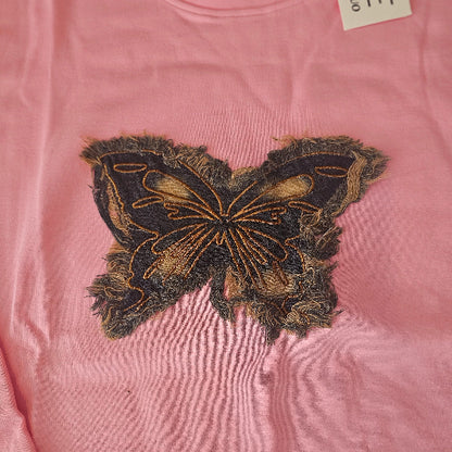 Pink garment with a decorative patch on a pink background
